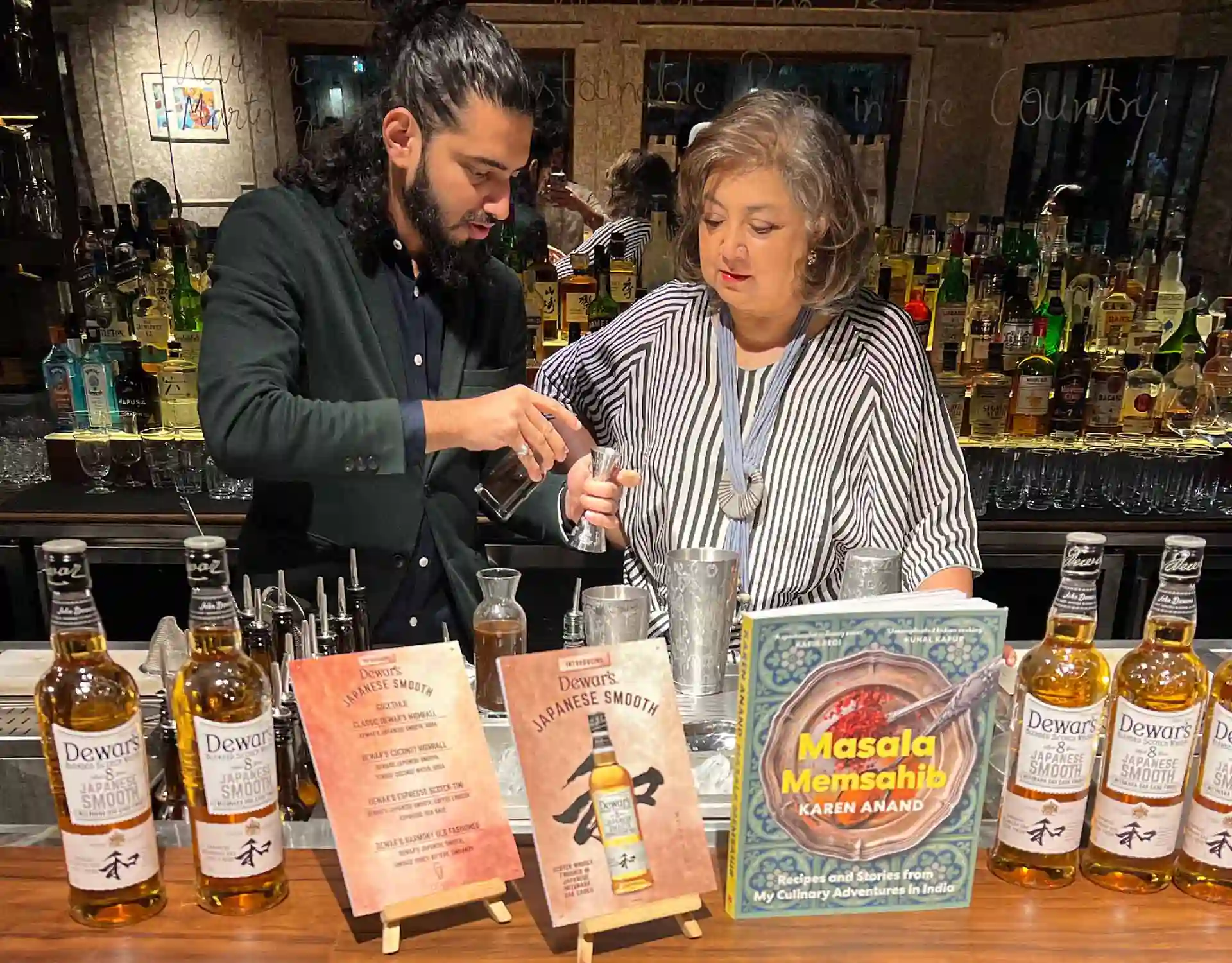 The bartender is instructing cocktail mixing techniques during a book launch event at Cobbler and Crew.
