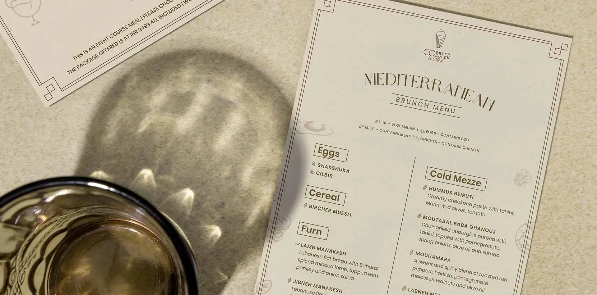 Mediterranean brunch menu on textured background with cocktail glass.
